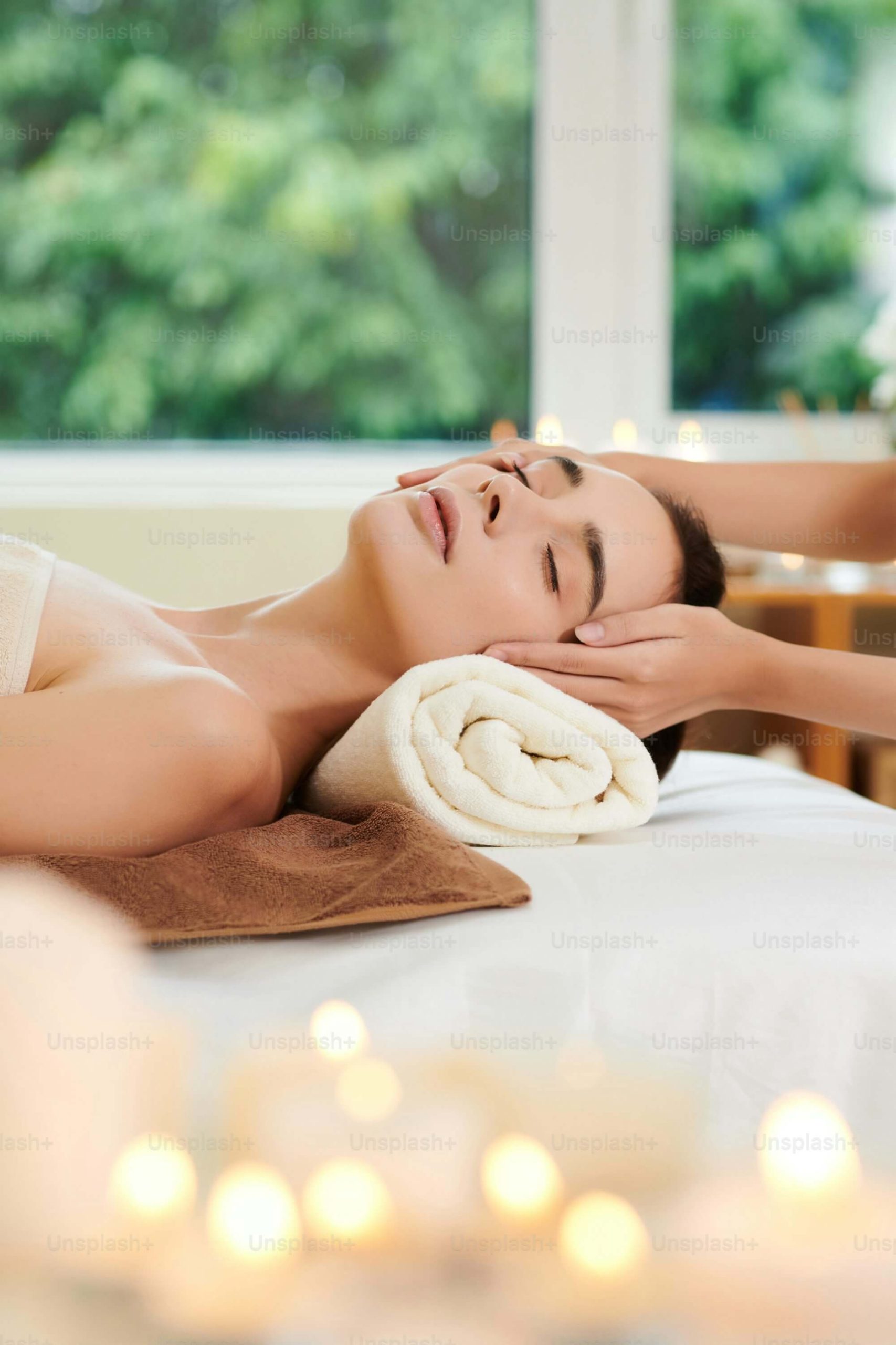 Woman receiving a relaxing head massage, surrounded by warm lights and a calming, stress-free atmosphere.