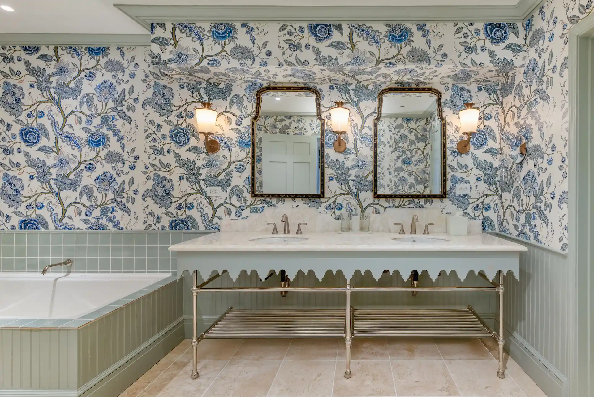 The luxurious bathroom of the presidential suite, adorned with floral patterns on the walls and elegant bronze-framed mirrors.