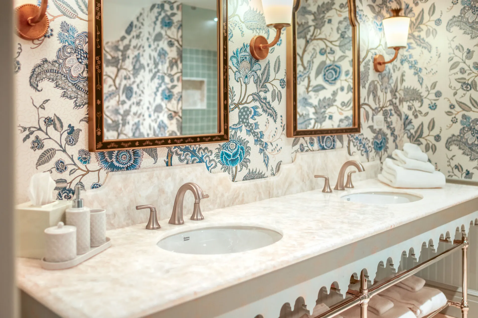 Elegant bathroom at the Sanderling Hotel, featuring dual sinks and beautifully adorned floral-patterned walls.